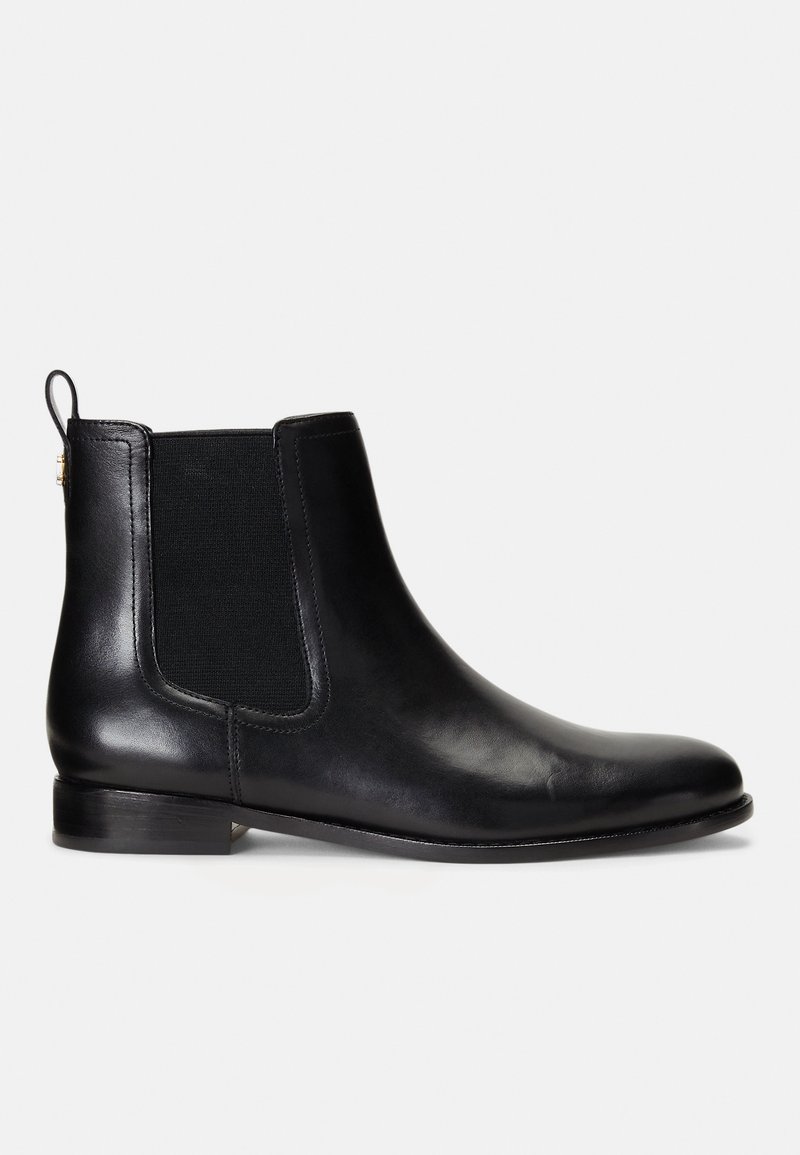 Bottine Chelsea en cuir noir avec panneau latéral élastique, languette à l'arrière, petit talon empilé, et bout arrondi sur fond blanc.