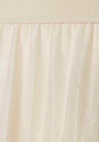 Cremefarbener Tüllstoff mit einer weichen, transparenten Textur, der einen subtilen Schimmer und ein gerafftes Design aufweist, ergänzt durch einen glatten Bund.