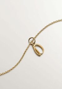 Collar de cadena de oro con un cierre decorativo en forma de lazo. Presenta acentos ovalados en el cierre y un diseño de cadena fina. Acabado suave y brillante.