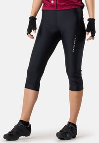 Schwarze Radfahr Capri-Hosen mit einer enganliegenden Passform, glatter Textur, knielangen Bündchen und einem kleinen Logo auf der linken Seite.