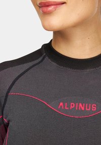 Czarny sportowy top z teksturowanym wzorem, z okrągłym dekoltem i różowymi akcentami. Logo "ALPINUS" jest wyraźnie widoczne.