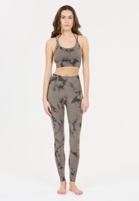 Conjunto de sujetador deportivo y leggings en gris con un patrón mármol negro. La tela es suave, con un diseño ajustado y tirantes ajustables en la parte superior.