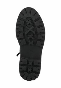 Black rubber shoe sole featuring a textured, tread pattern with deep grooves and raised accents for traction and durability.