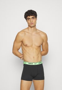 Schwarze Baumwoll-Boxershorts mit einem neongrünen Nike-Logo-Bund. Aus gestrecktem Material mit einer glatten Textur und passgenauer Form.