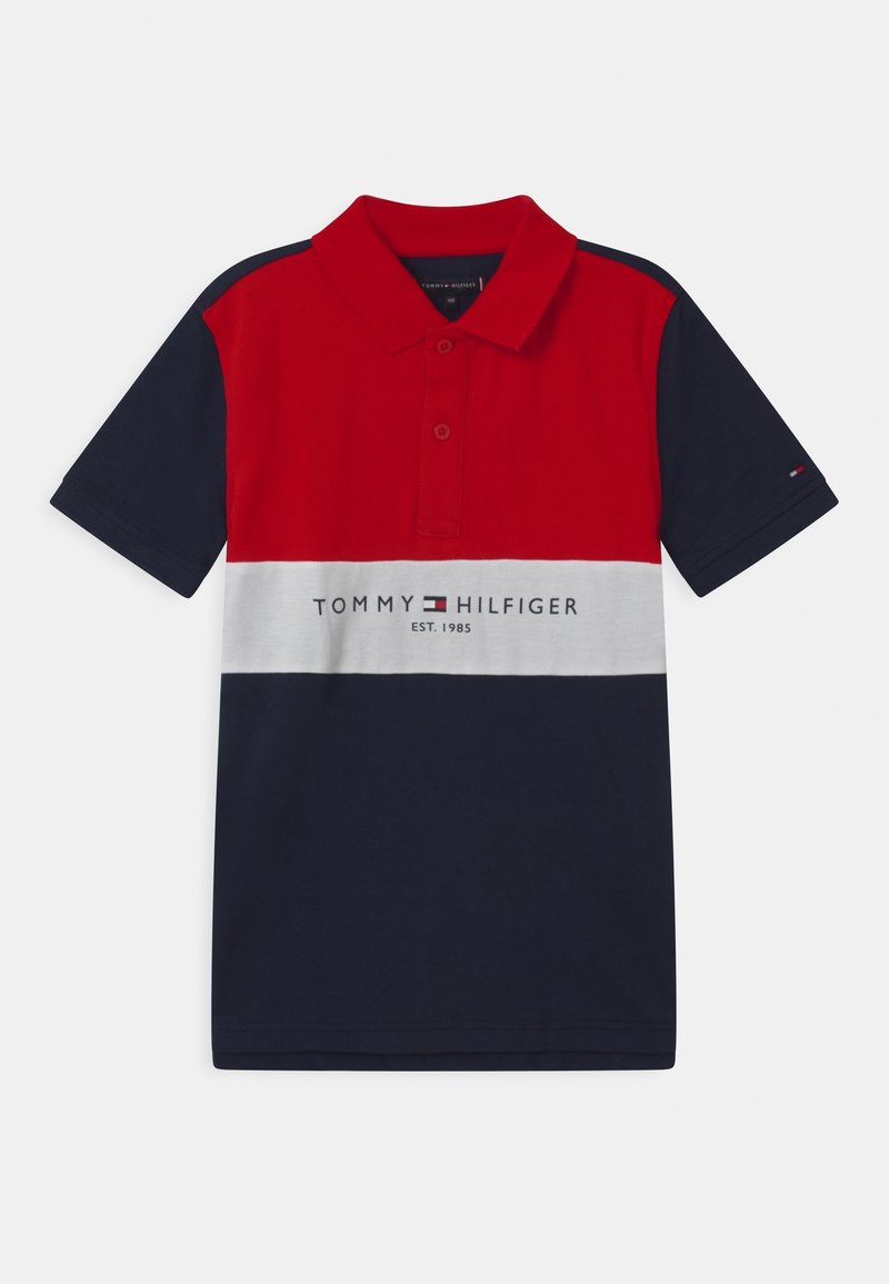 Pánská polokošile s barevnými bloky v červené, bílé a námořnické barvě, se třemi knoflíky na léze a textem "TOMMY HILFIGER EST. 1985" na přední straně.