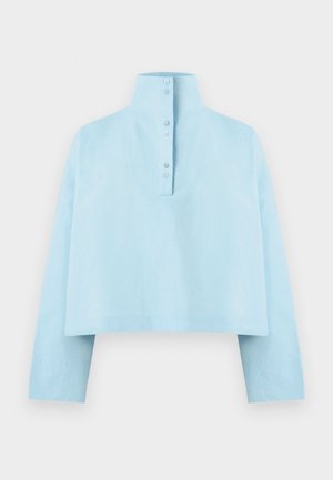 Camisa corta de manga larga azul claro con cuello alto y seis botones en la tapeta delantera.
