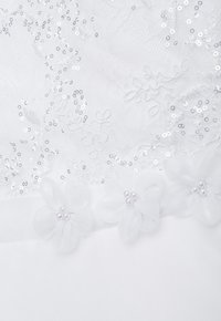 Weißer Stoff mit aufwändiger Spitze, bestickt mit Pailletten, und drei strukturierte Chiffonblumen mit perlenbesetzten Zentren entlang des unteren Randes.