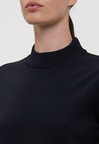 Zwarte hoge hals trui met een soepele brei textuur, nauwsluitend ontwerp en een eenvoudige, minimalistische stijl zonder versieringen.