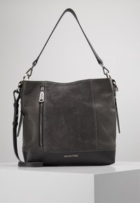 Szara skórzana torebka o fakturowanej powierzchni, z jednym paskiem na ramię, zasuwaną kieszenią z przodu i gładką czarną podstawą.