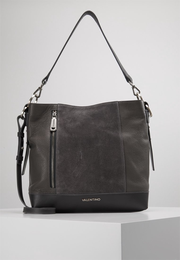 Szara skórzana torebka o fakturowanej powierzchni, z jednym paskiem na ramię, zasuwaną kieszenią z przodu i gładką czarną podstawą.