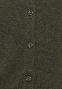 Tmavozelená pletená látka s troma vertikálne umiestnenými čiernymi plastovými gombíkmi, ktoré sú prišité s dvoma otvormi.