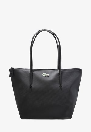 Sac cabas en cuir noir texturé avec deux fines poignées et un petit logo crocodile vert centré sous la fermeture éclair.