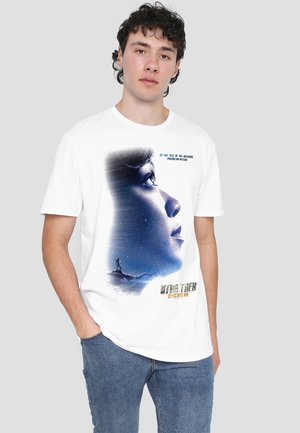 Weißes Baumwoll-T-Shirt mit einem grafischen Druck des Profils einer Frau vor einem sternenübersäten Hintergrund mit dem Text "Star Trek: Entdeckungen".