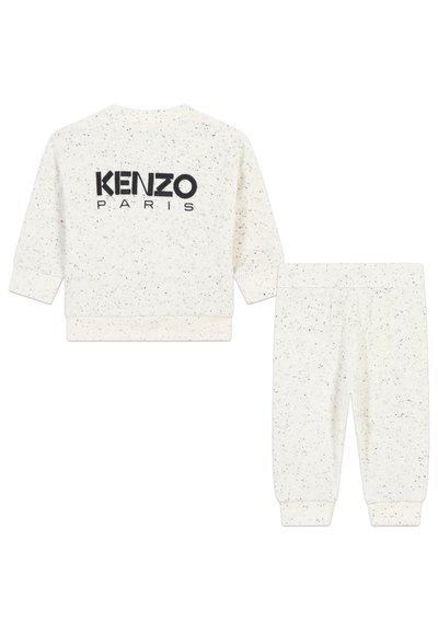 Sweatshirt blanc à pois et pantalon de survêtement assorti, arborant un logo noir "KENZO PARIS" au dos. Tissu doux et texturé avec des poignets élastiques.