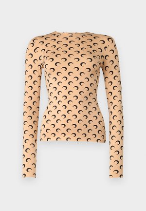 Langsleeve top van rekbare stof in licht perzik met een zwart halve maanpatroon overal en een ronde halslijn.