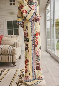 Halat galben cu model ce prezintă crabi și elemente nautice, cu accente albastre și roșii, croială lejeră și mâneci largi.