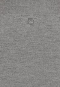 Il tessuto a coste grigio presenta un logo a basso profilo sulla vita. La texture è morbida ed elastica, con un sottile motivo melangiato.