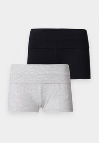 Deux paires de shorts extensibles, une noire et une gris clair, pliées et exposées à plat sur un fond blanc.