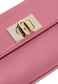 Růžová texturovaná kožená psaníčko se zlatým kovovým uzávěrem. Má hladký povrch a obdélníkový tvar. Uzávěr zobrazuje jedinečný design.