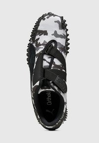 Zwart-wit camouflage geprinte schoen met een synthetisch bovenwerk, klittenbandsluitingen en een getextureerde rubberen zool ontworpen voor grip.
