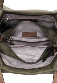 Intérieur d'un sac en tissu vert olive avec plusieurs compartiments, doublure gris clair présentant un motif de logo répété, et une poche zippée.