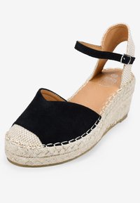 Espadrilles de cuña de ante negro con detalle de yute tejido, punta abierta, correa al tobillo con hebilla y plataforma texturizada beige.