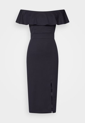Vestido midi preto, fora do ombro, com um detalhe de babado ondulado na gola, textura suave e uma fenda lateral para um estilo adicional.