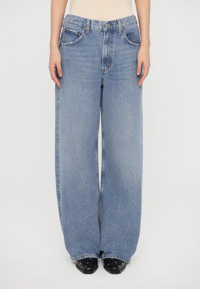 Jeans a gamba larga di un blu chiaro con vita alta, realizzati in denim. Presentano un classico stile a cinque tasche e una leggera sfumatura per aggiungere texture.