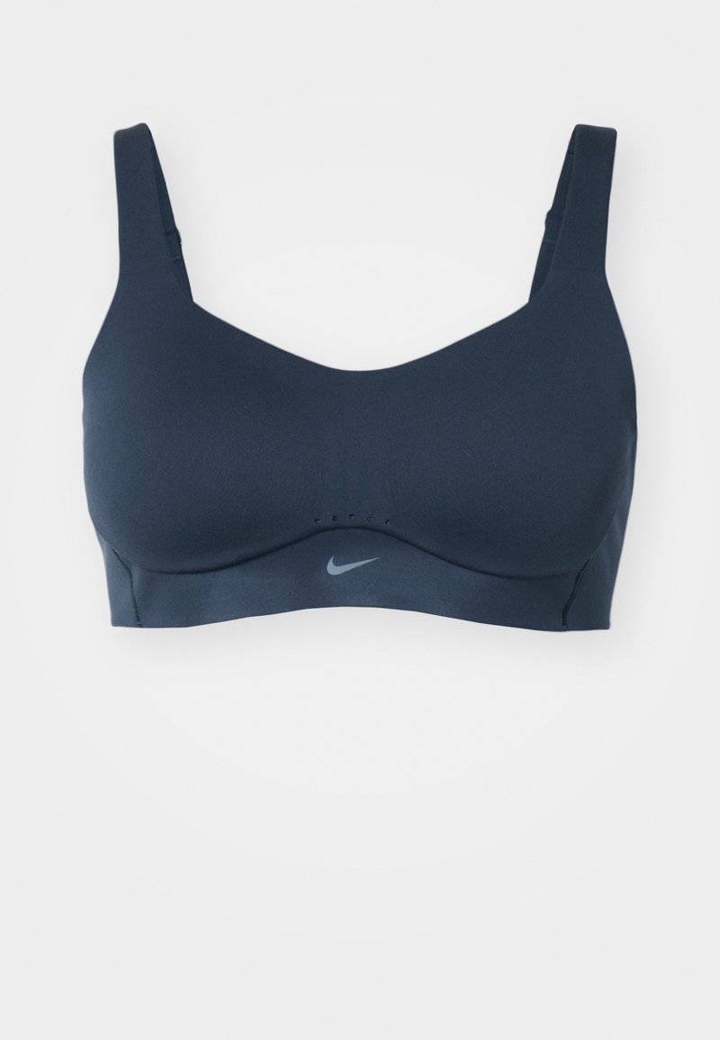 Sujeción deportiva en color azul marino con tirantes anchos y escote en forma de V. Presenta el logo de Nike en gris, tejido suave y detalles de costura sutiles.