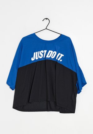 Camiseta deportiva holgada azul y negra colgada en una percha negra con el texto blanco "JUST DO IT." en el pecho.