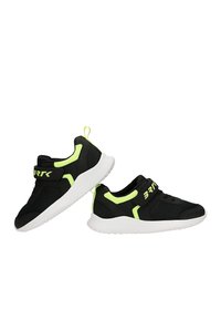 Paire de baskets noires avec semelles blanches et accents jaune néon, équipées d'une bride velcro et d'une languette au talon.