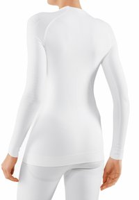 Top lungo sportivo bianco a maniche lunghe realizzato in tessuto a coste e elasticizzato. Design senza cuciture con dettagli testurizzati sulle spalle e sulla schiena. Silhouette aderente.