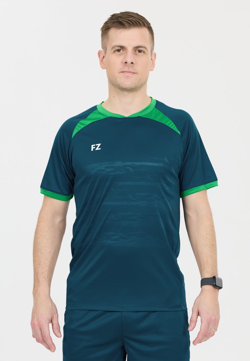 Mörkt teal sporttröja med gröna accenter vid kragen och ärmarna. Har ett subtilt texturerat mönster och visar FZ-logotypen på framsidan.