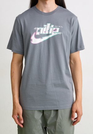 Szara bawełniana koszulka z kolorowym logo "Nike" i napisem "Just Do It", z krótkimi rękawami i klasycznym okrągłym dekoltem.