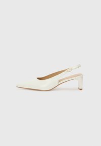 Valkoinen patenttilahja slingback-kengä, jossa on terävä kärki ja matala lohkokorko. Varustettu huomaamattomalla hihnalla, jossa on kultasävyinen solkiyksityiskohta.