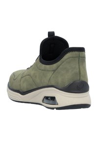 Baskets en daim vertes avec un col et un talon élastiques noirs, une semelle intermédiaire crème et un amorti visible sur la semelle extérieure. Design minimaliste.