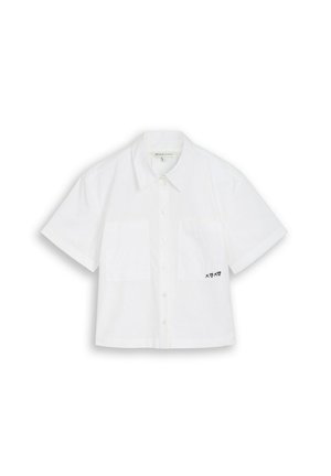 Balta īss piedurkņu krekls ar pogām, apkakli, krūšu kabatu un mazu melnu izšūtu "XOXO" ar sirsniņām pie apakšējā labā kabata.