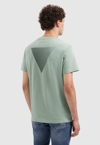 Mint green cotton t-shirt with a triangular, striped graphic in dark green on the back. Short sleeves and a round neckline.