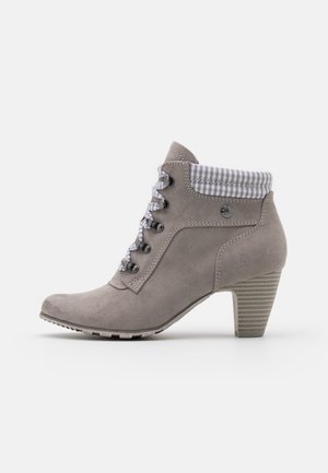 Stivaletto alla caviglia in camoscio grigio con polsino in tessuto a quadri, chiusura frontale con lacci, dettagli in metallo argento e tacco in stile legno; suola texturizzata per una migliore presa.