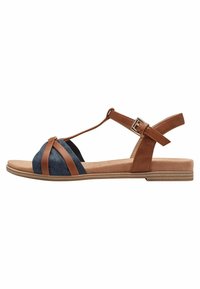 Sandali in pelle marrone e tessuto blu navy con design a T-strap, soletta testurizzata e cinturino alla caviglia regolabile. Suola piatta con dettagli sottili.