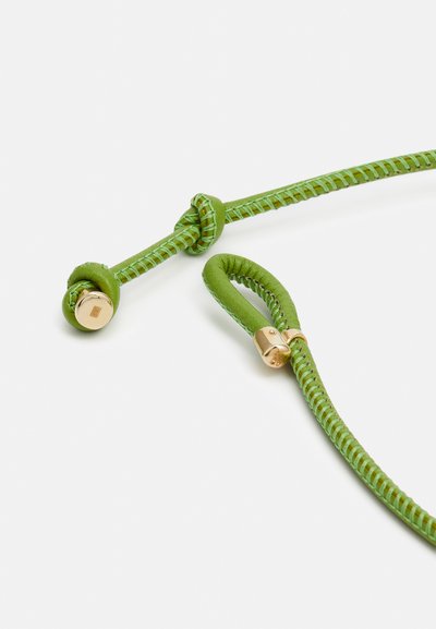 Zeleni usnjeni kabel s zlatimi kovinskimi dodatki, ki se ponaša z vozlanim oblikovanjem in tkano teksturo. Gladka površina s kontrastnimi šivi.