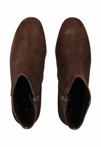 Bottines en daim marron avec une texture lisse, comprenant une fermeture éclair sur le côté et un design à bout rond. La semelle est plate avec une adhérence minimale.