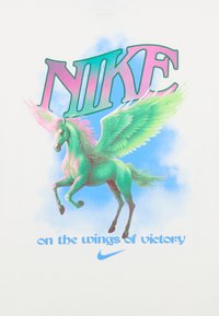 Balta marškinėliai su spalvinga piešiniu, vaizduojančiu sparnuotą vienaragį. Tekstas apima „NIKE“ ryškiomis, daugiaspalvėmis raidėmis ir „ant pergalės sparnų.“