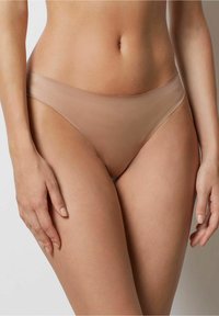Nude naadloze bikini slipjes hebben een soepele, elastische tailleband, een ontwerp met minimale bedekking en een zachte textuur voor comfort.