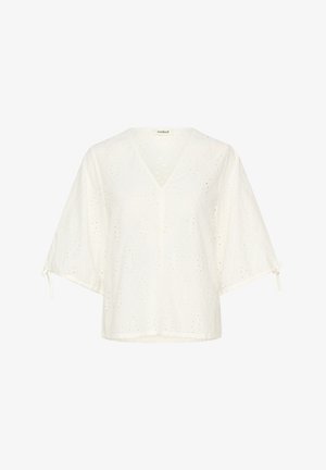 Bijeli top od lagane tkanine, s V-izrezom, rukavima poput šišmiša, uzorcima s rupicama i detaljima za vezanje na rubovima rukava.