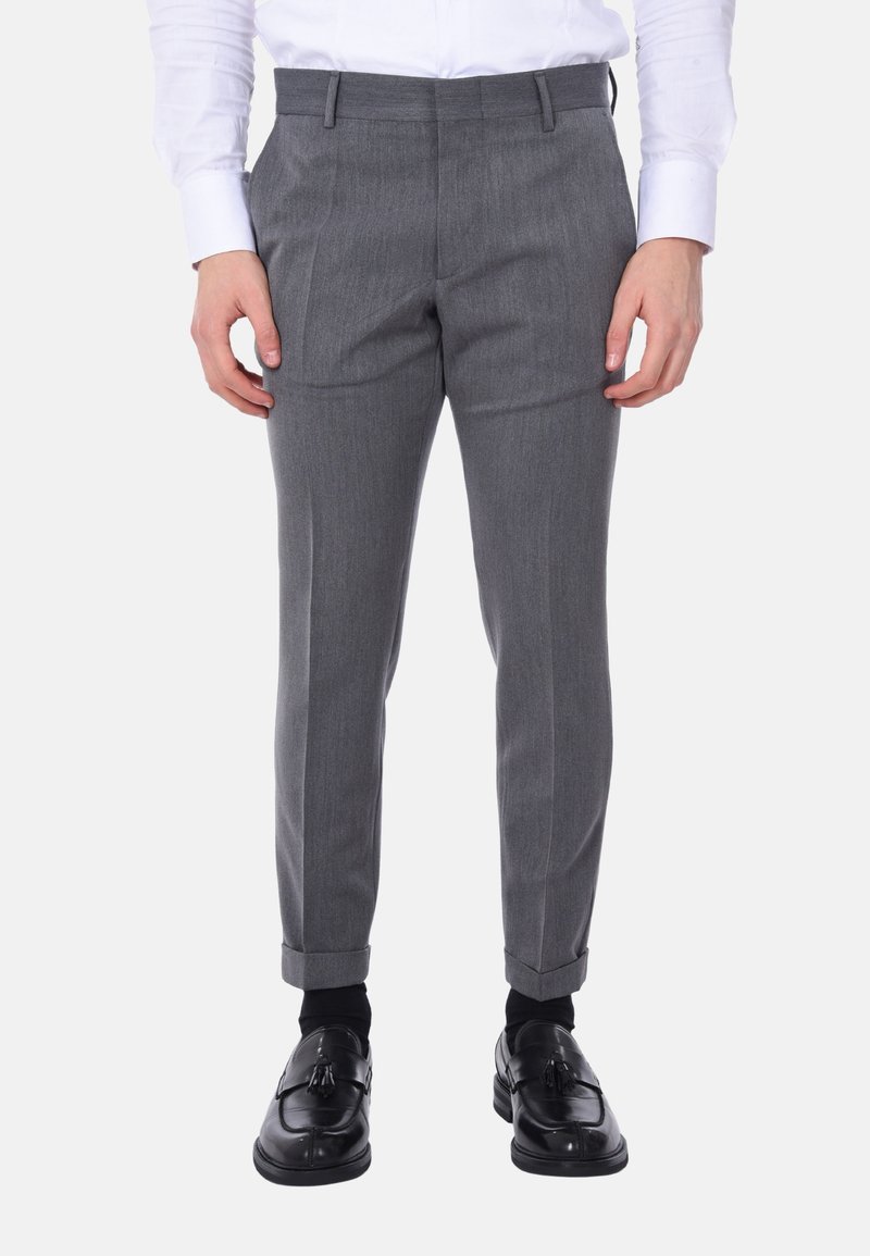 Pantaloni grigi su misura realizzati in tessuto tessuto, caratterizzati da una vestibilità slim, pieghe frontali e risvolti, abbinati a mocassini neri.