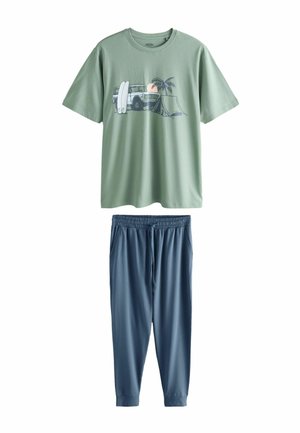 Hellgrünes T-Shirt mit kurzen Ärmeln und Strandmotiv, kombiniert mit dunkelblauen Jogginghosen mit Kordelzug.