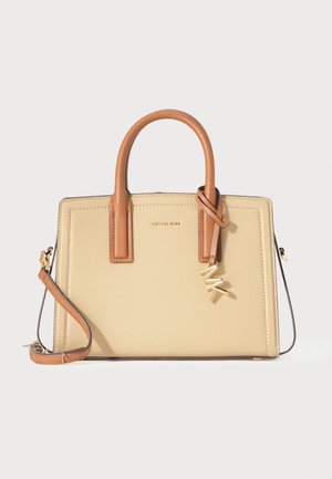 Sac à main en cuir beige et marron avec poignées supérieures, bandoulière amovible et breloque logo dorée à l'avant sur fond blanc.