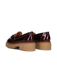 Burgundy patent leather shoes with a chunky tan rubber sole and decorative bow detail, featuring a sleek, rounded toe design.