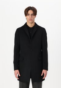 Cappotto nero; tessuto misto lana; chiusura con un bottone; rever con punte; due tasche frontali; vestibilità su misura; texture liscia; design lungo fino al ginocchio.